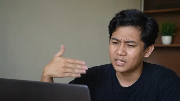 Pria mengipasi laptop yang kepanasan
