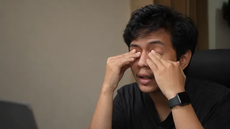 Editor video kelelahan di meja kerja malam hari