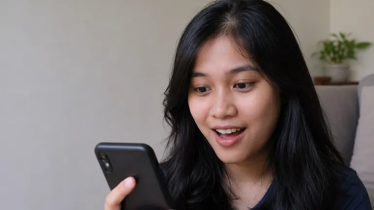 Perempuan terkejut senang membuka notifikasi