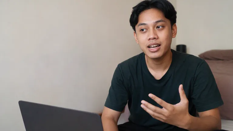 Pria duduk bersila menjelaskan sesuatu