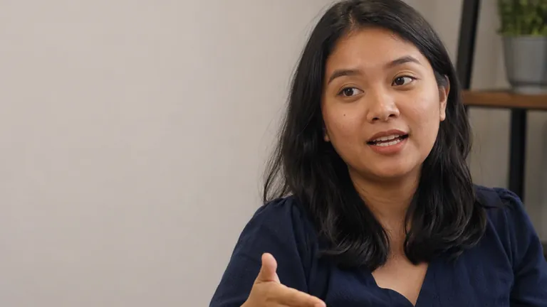 Pemimpin tim perempuan menjelaskan dengan tangan terbuka