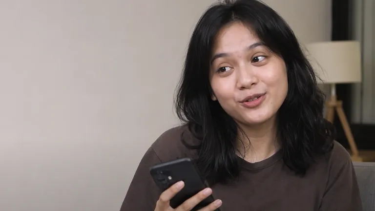 Perempuan menggeleng sambil tersenyum