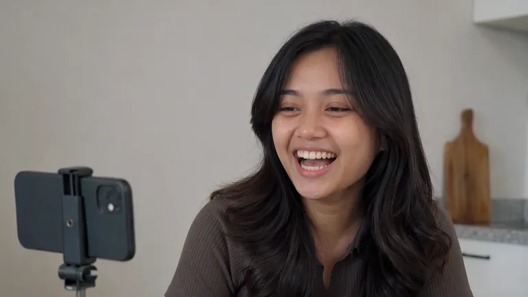 Perempuan tertawa merekam Reels di dapur