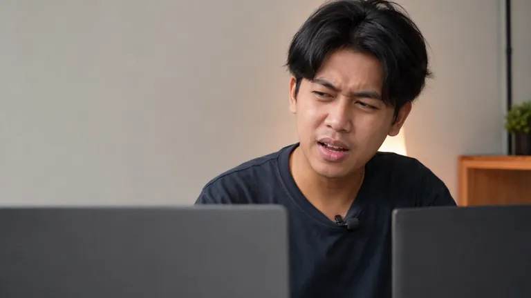 Pria membandingkan dua laptop