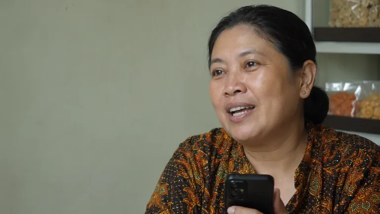 Pemilik warung tersenyum bangga di balik meja