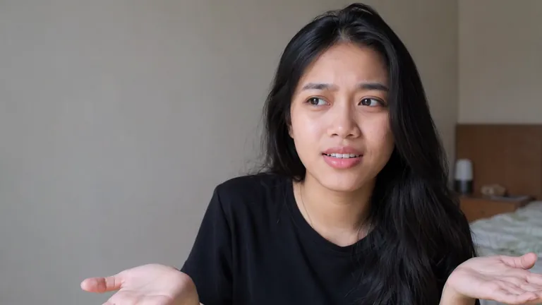 Perempuan mengangkat bahu dengan bingung